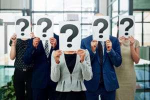 people holding placards with question marks on them